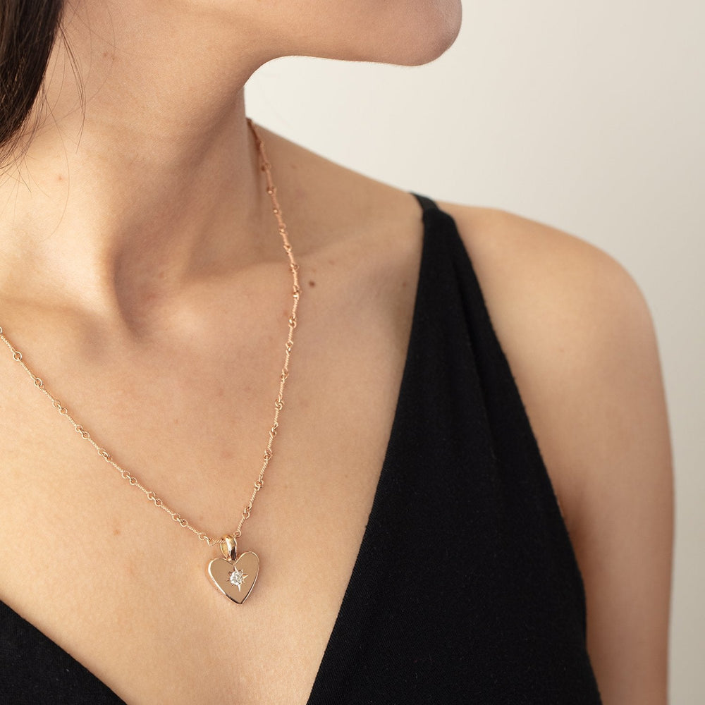 
                      
                        Detail view of model wearing small classic heart pendant with white diamond by Betsy Barron Jewellery.
                      
                    