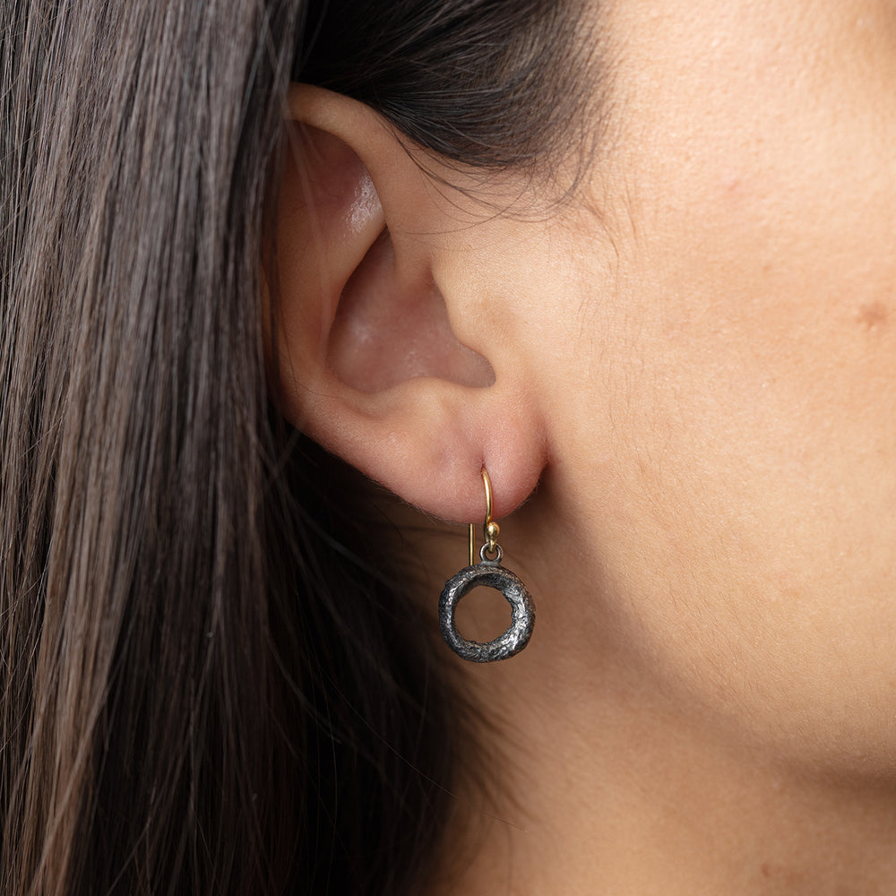 Model wearing oxidized sterling silver Organic Donut Earring in right ear